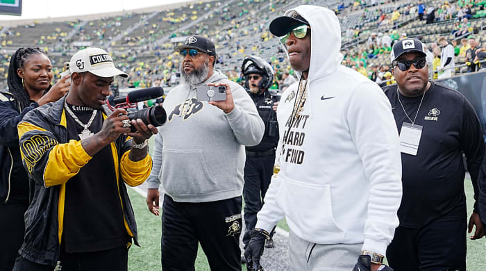 Deion Sanders walks onto the field at Oregon’s Autzen Stadium.